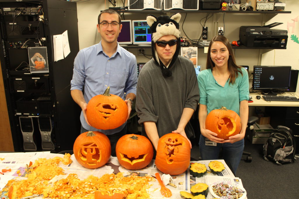 students during halloween holding carved pumpkins